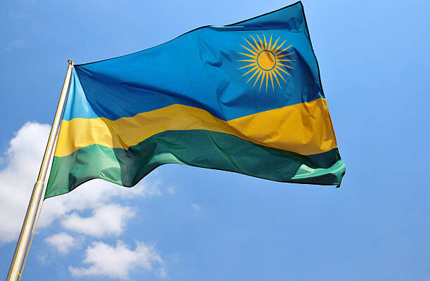Kigali, Rwanda: Rwanda flag against blue sky - sun and blue, yellow and green stripes - photo by M.Torres